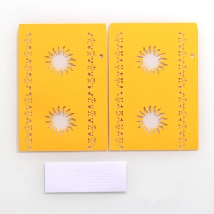 Detail view of yellow laser-cut sun paper lanterns with hollowed decorative patterns