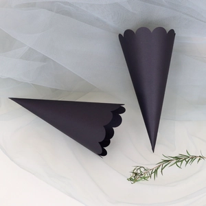 Detail of black wave-edged petal paper cones on white mesh for wedding flower petals