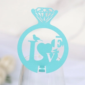 Sky blue laser-cut diamond ring card with LOVE design placed on a glass rim
