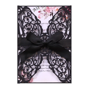 Detailed laser-cut hollow butterfly wedding invitation with a black satin ribbon bow