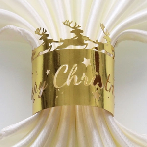 Detailed view of a gold Christmas napkin ring with reindeer and Merry Christmas cutout
