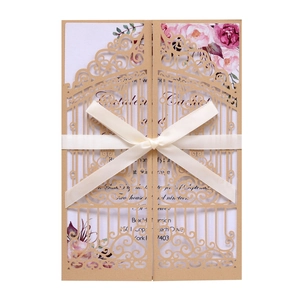 Close-up of laser-cut gate pattern wedding invitation with elegant satin bow detail