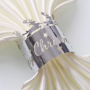 Close-up of silver laser-cut metal napkin ring with reindeer and Merry Christmas text