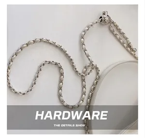 Detail of white leather and silver metal chain strap with adjustable ball buckle