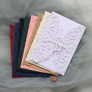 Macro detail of laser-cut invitation cards in various colors with elegant floral patterns