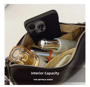 Donkerbruine leren crossbodytas met ruim interieur en een veilig vak met ritssluiting