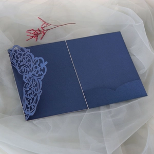 Macro view of navy blue laser-cut lace pattern on pearlescent wedding invitation cover