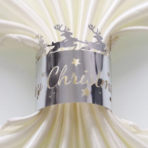 Detailed view of silver laser-cut Merry Christmas napkin ring with reindeer and star patterns