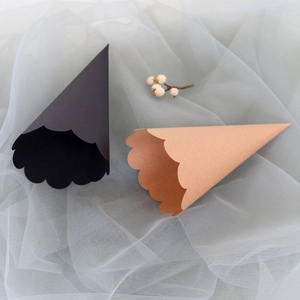 Detail of cone-shaped wedding petal cones with wavy edges in black and kraft colors