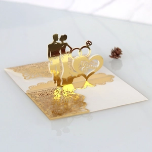 Detail of laser-cut 3D gold wedding card with Mr & Mrs ring silhouette and lace pattern
