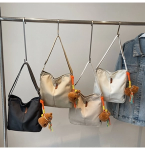 Détail de sacs seaux en toile multicolores avec pendentifs ours et étiquettes en cuir