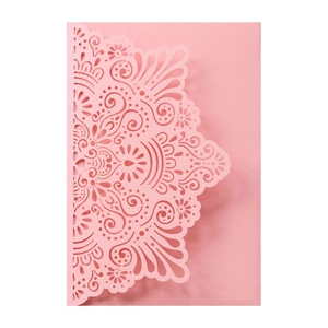 Detail of pink laser-cut invitation cover with elegant symmetric mandala pattern