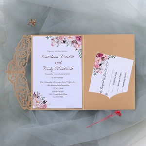 Detail of laser-cut pearl paper wedding invitation with floral insert and RSVP card