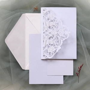 Laser-cut wedding invitation set with pearl white hollow cover and matching envelopes