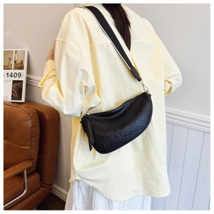 Detail van de zwarte halve maan crossbody tas met rimpel leer en een brede canvas schouderriem