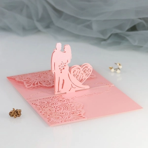 Detail of pink laser-cut 3D wedding card with Mr & Mrs silhouette and intricate lace pattern