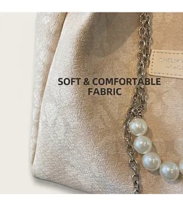 Detail of cream tote bag with textured weave fabric, silver chain and large pearl strap