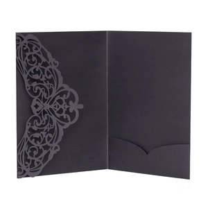 Macro view of laser-cut floral pattern and pocket on black matte wedding invitation cover