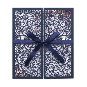 Elegant navy blue laser-cut wedding invitation with satin ribbon and floral pattern