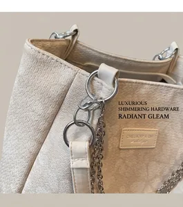 Detail of beige textured tote bag featuring silver chain and metal ring accents