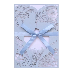 Detail of laser-cut wedding invitation featuring a couple silhouette and light blue ribbon bow
