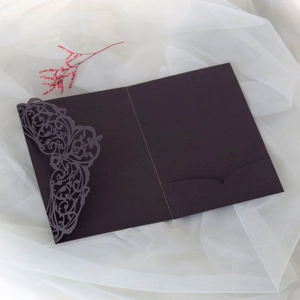 Detail of laser-cut hollow floral pattern on a dark red pearlescent wedding invitation