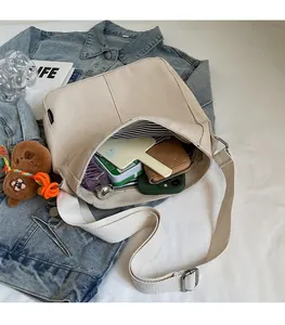 Vue macro de l'intérieur rayé spacieux du sac seau en toile beige avec effets personnels