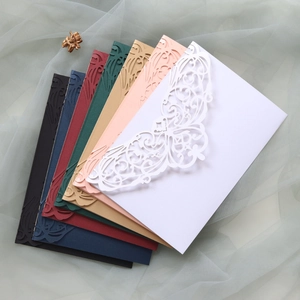 Macro detail of laser-cut lace butterfly patterns on pearl paper wedding invitations