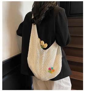 Detail of white crochet tote bag showing hollow knit pattern and colorful floral embroidery