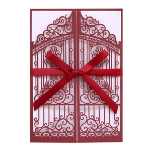 Detailed laser-cut burgundy wedding invitation card with elegant satin ribbon bow and insert