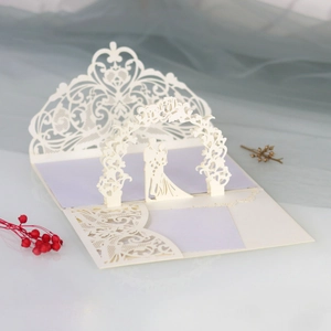 Macro detail of laser-cut 3D wedding invitation with couple silhouette and floral patterns