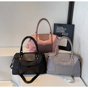 Détail des sacs cabas en nylon imperméable noir, rose et gris avec poignées en cuir élégantes