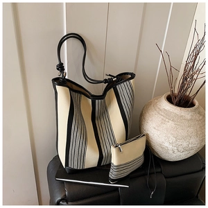 Detail of striped canvas tote bag set with matching small zipper pouch in minimalist style