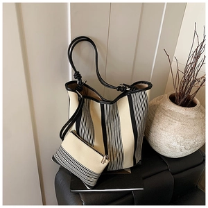 Detail of black and white striped tote bag set with leather knotted shoulder straps