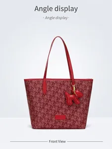 Detail der roten Ruyi-Tasche mit Logo-Patch und Plüsch-Hundeanhänger-Befestigung
