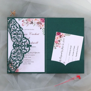 Detail of dark green laser-cut wedding invitation with floral insert and RSVP card