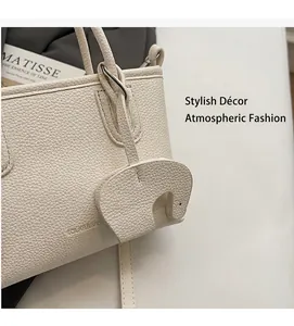 Detail of white lychee leather texture on a tote bag featuring a cute elephant charm