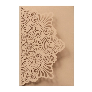 Macro shot of laser-cut mandala lace pattern on kraft wedding invitation sleeve