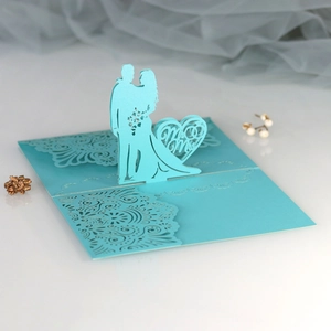 Macro shot of laser-cut Mr & Mrs wedding invite with 3D light blue bride and groom