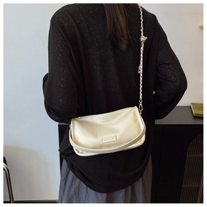 Detail view of cream PU leather crossbody bag featuring metal ball chain and G&HEKA logo