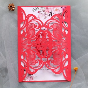 Detail of red laser-cut wedding invitation featuring elegant patterns and floral insert