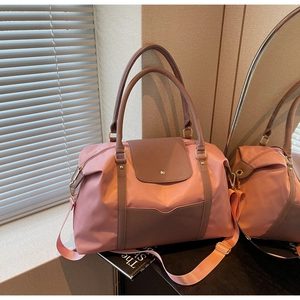 Détail d'un grand sac cabas rose avec garniture en cuir brun et bandoulière amovible