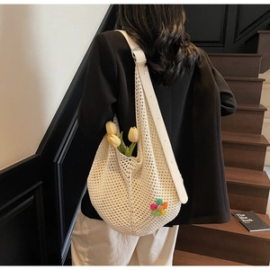 Detail of crochet tote bag with colorful flower accent and white leather strap