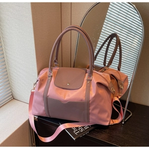 Détail d'un grand sac fourre-tout rose en nylon avec anses en cuir et reflet miroir
