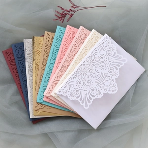 Macro shot of assorted laser-cut lace wedding invitations with intricate floral patterns