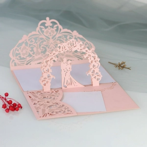 Intricate 3D laser-cut wedding invitation featuring a romantic couple silhouette in pink