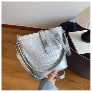 Detail of silver stone pattern bucket bag with metal twist lock and adjustable strap