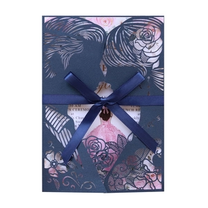 Detail of laser-cut invitation with blue ribbon and pink rose girl inner card