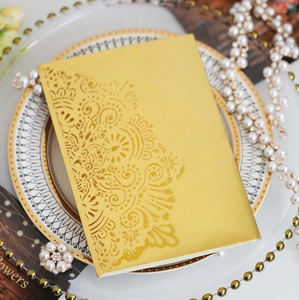 Close-up of golden laser-cut hollow lace design on elegant wedding invitation card