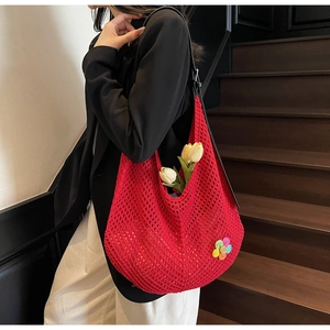 Detailed view of red crochet tote bag with rainbow flower and hollow woven texture